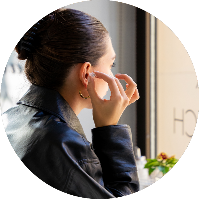 Schallwerk Gehörschutz Frau mit Invisible+ im Café